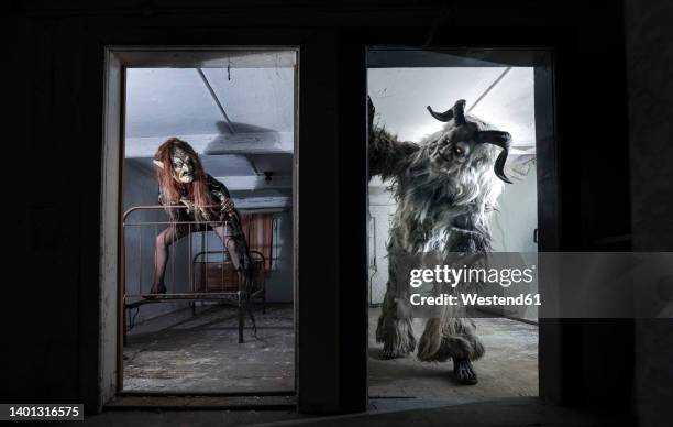 monster looking for witch seen through door of horror house - krampus stock pictures, royalty-free photos & images