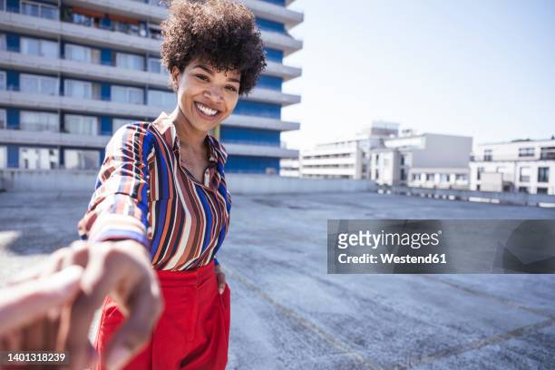 happy woman holding hand of boyfriend at parking deck - parking deck stock pictures, royalty-free photos & images