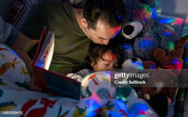 falling asleep with a bedtime story - good night kisses stock pictures, royalty-free photos & images