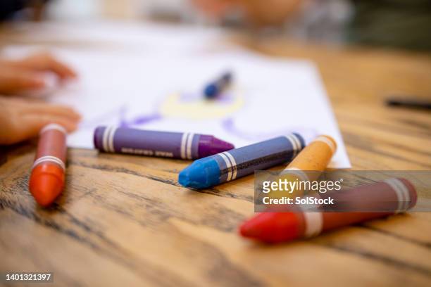 colourful crayons on table - child care stockfoto's en -beelden