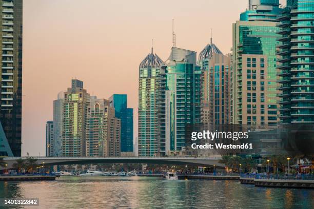 united arab emirates, dubai,dubai marina at dusk with bridge and tall downtown skyscrapers in background - dubai water canal stock pictures, royalty-free photos & images
