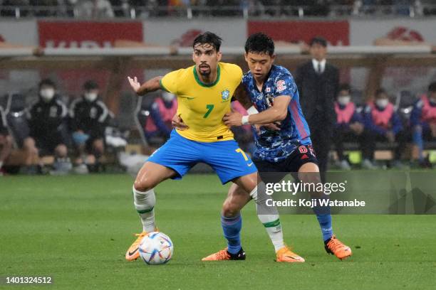 Lucas Paqueta of Brazil controls the ball under pressure of Wataru Endo of Japan during the international friendly match between Japan and Brazil at...