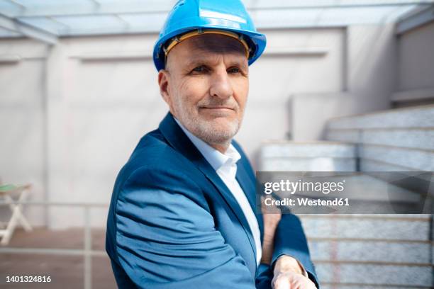 businessman with arms crossed at construction site - 63 building stock pictures, royalty-free photos & images