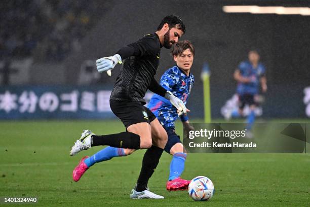 Alisson of Brazil controls the ball under pressure of Kyogo Furuhashi of Japan during the international friendly match between Japan and Brazil at...