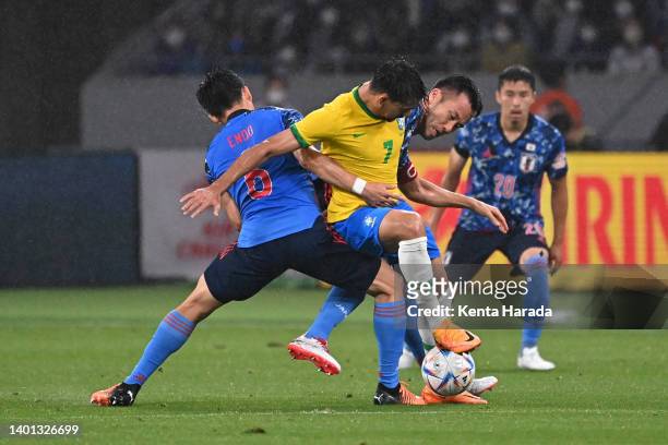 Lucas Paqueta of Brazil competes for the ball against Wataru Endo and Maya Yoshida of Japan during the international friendly match between Japan and...