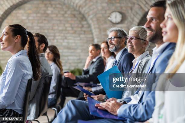 große gruppe glücklicher unternehmer auf einem business-seminar im sitzungssaal. - men and women in a large group listening stock-fotos und bilder