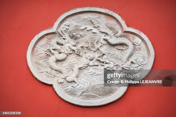 dragon bas-relief on a red wall in wenshu monastery - bas reliëf stockfoto's en -beelden