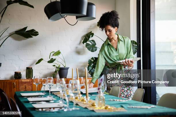 mujer joven colocando su mesa de comedor antes de una cena - azafata fotografías e imágenes de stock