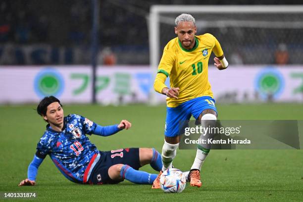 Neymar Jr. Of Brazil goes past Takumi Minamino of Japan during the international friendly match between Japan and Brazil at National Stadium on June...