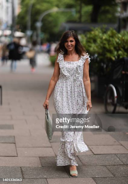 Anna Wolfers seen wearing a long maxi dress with floral print, a white and light green crochet bag and light green high heels on June 02, 2022 in...