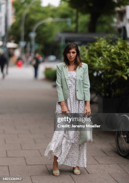 Anna Wolfers seen wearing a light green blazer, long maxi dress with floral print, a white and light green crochet bag and light green high heels on...