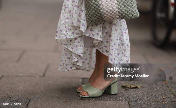 Anna Wolfers seen wearing a long maxi dress with floral print, a white and light green crochet bag and light green high heels on June 02, 2022 in...