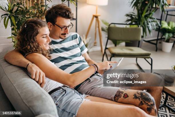 let's check the online city guide - couple with ipad in home stock pictures, royalty-free photos & images