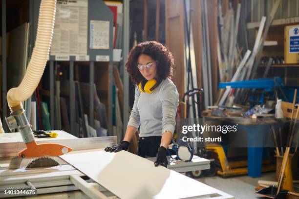 female carpenter in the workshop - depósito de madeiras imagens e fotografias de stock