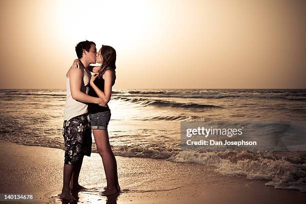 couple kissing at beach sunset - ashdod stock pictures, royalty-free photos & images