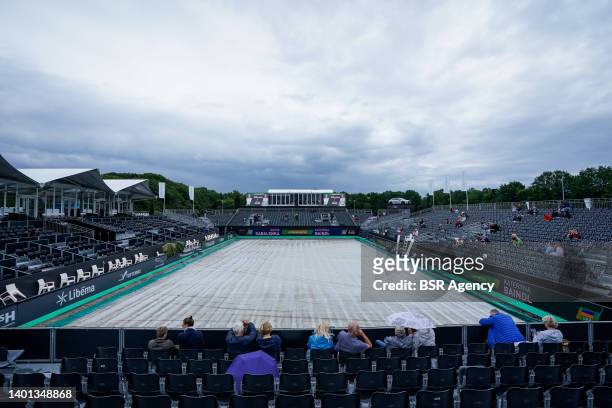 Spectators are waiting while the centre court is covered due to a rain delay during Day 1 of the Libema Open Grass Court Championships at the...
