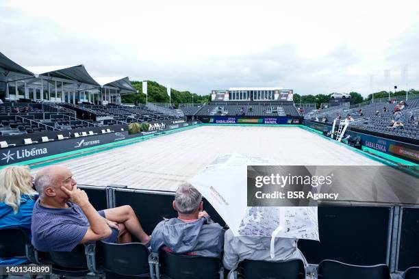 Spectators are waiting while the centre court is covered due to a rain delay during Day 1 of the Libema Open Grass Court Championships at the...