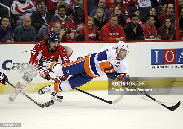 Mathieu Perreault of the Washington Capitals trips up Mark Streit of the New York Islanders at the Verizon Center on February 28, 2012 in Washington,...