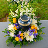 Cremation urn at funeral ceramony with floral arrangement