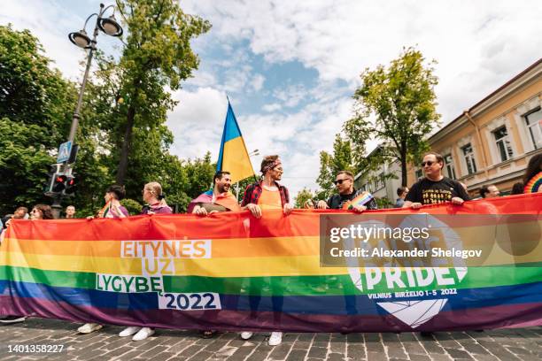 baltic lgbtq+ stolz in vilnius, marsch und protest der menschen gegen diskriminierung aufgrund des geschlechts und krieg in der ukraine. protest mit cover, regenbogenfahne und luftballon an der europäischen straße. glückliches fußgängerwandern für me - baltikum stock-fotos und bilder