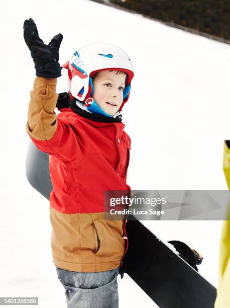 boy high-fives his snowboarding instructor on the slopes in austria. - ski high five stock pictures, royalty-free photos & images