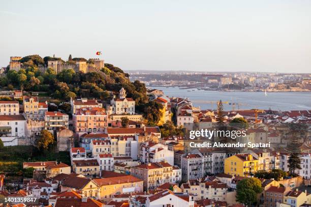 lisbon cityscape with st. george castle (castelo de são jorge) at sunset, portugal - lisbonne photos et images de collection