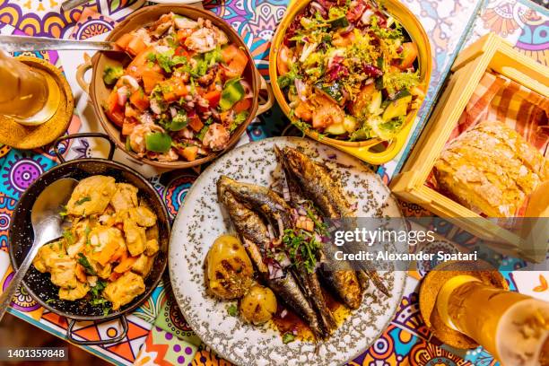 traditional portuguese dinner with griller sardines and octopus salad, overhead view - portuguese culture stock pictures, royalty-free photos & images