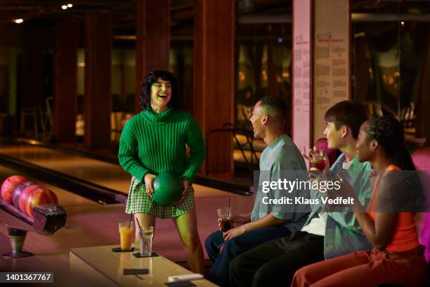 woman holding ball talking with friends - bowling woman stock pictures, royalty-free photos & images