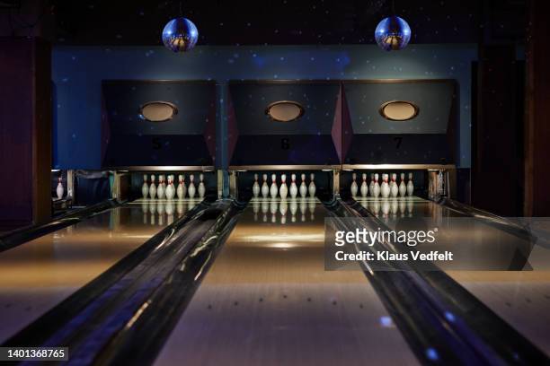bowling pins arranged on tracks at alley - bowler hat stock-fotos und bilder