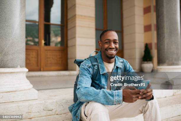 happy young university student using a smart phone outdoors - school life balance stock pictures, royalty-free photos & images