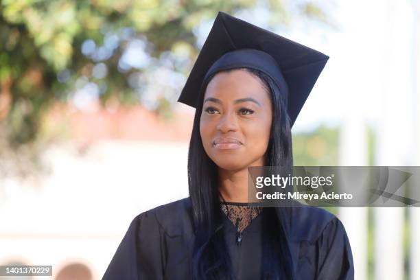 Portrait Of A Happy African American Woman With Her Thumbs Up Wearing A  Black Graduation Cap And Gown In An Public Park High-Res Stock Photo -  Getty Images