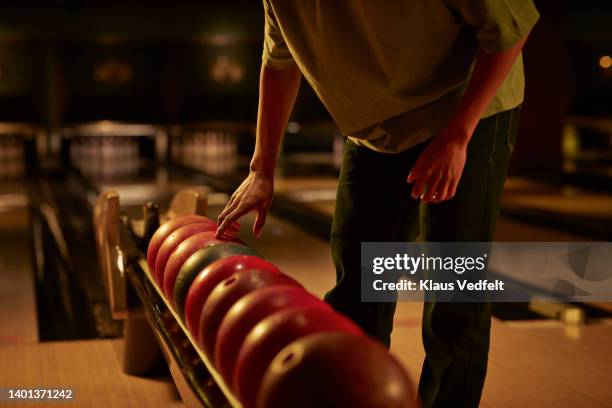 midsection of man picking bowling ball - bowlingbahn stock-fotos und bilder