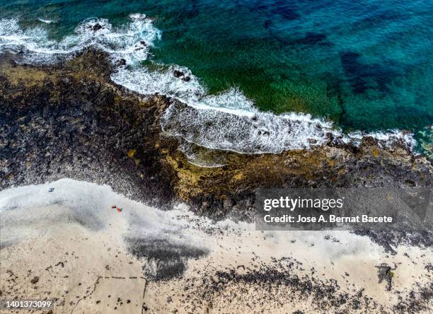aerial view of a coastal landscape with a sandy and rocky beach. - fuerteventura beach stock pictures, royalty-free photos & images