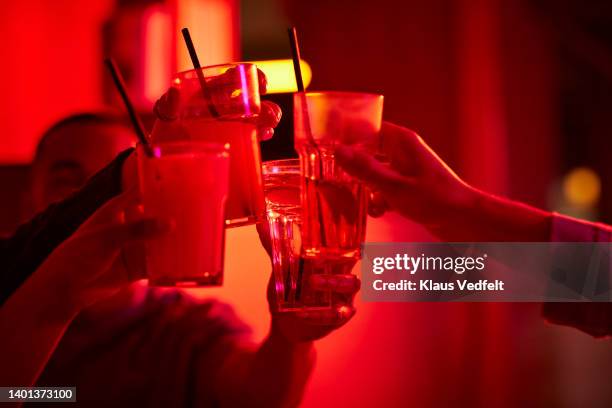 cropped image of friends toasting drink glasses - rubbing alcohol stock-fotos und bilder