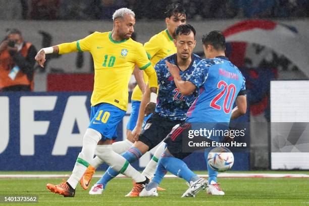 Neymar Jr. Of Brazil in action under pressure from Maya Yoshida and Yuta Nakayama of Japan during the international friendly match between Japan and...