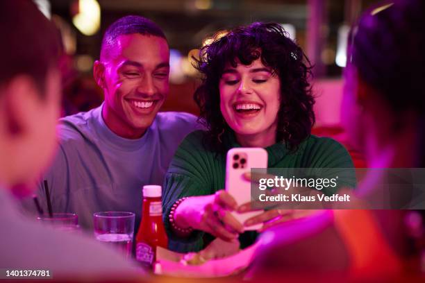 cheerful woman taking selfie with man - amigos hombres en restaurant fotografías e imágenes de stock