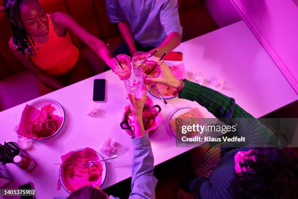 friends toasting drink glasses at table - friends toasting above table stock-fotos und bilder