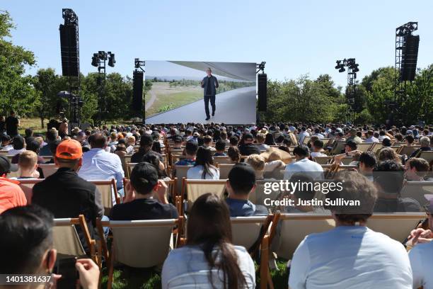 Apple CEO Tim Cook appears on a video screen as he delivers a keynote address during the WWDC22 at Apple Park on June 06, 2022 in Cupertino,...