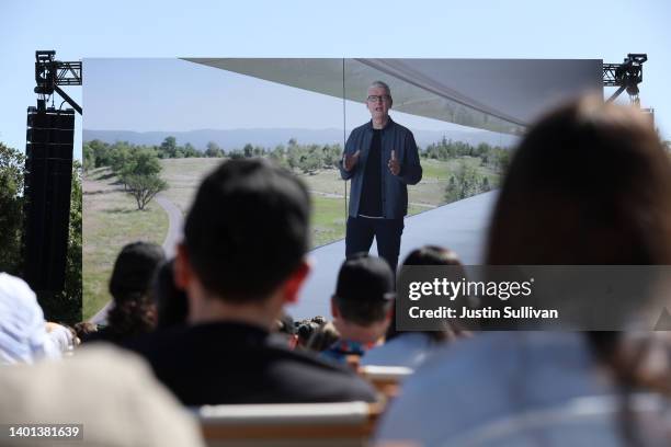 Apple CEO Tim Cook appears on a video screen as he delivers a keynote address during the WWDC22 at Apple Park on June 06, 2022 in Cupertino,...