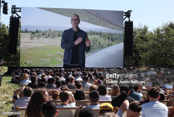 Apple CEO Tim Cook appears on a video screen as he delivers a keynote address during the WWDC22 at Apple Park on June 06, 2022 in Cupertino,...