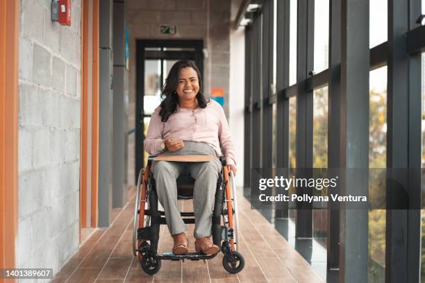 businesswoman in a wheelchair using smartphone - wheelchair stockfoto's en -beelden