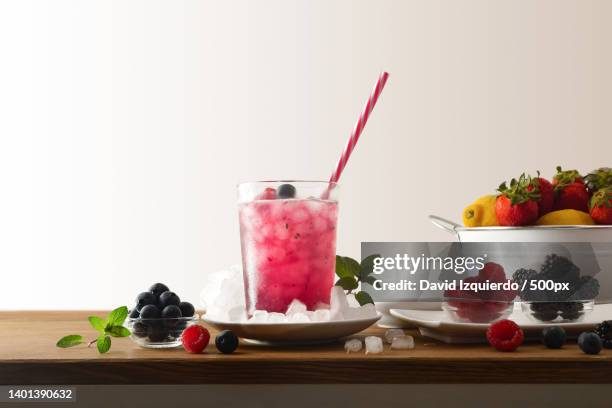 drink with berries and ice on wooden table isolated background - alcohol detox foto e immagini stock