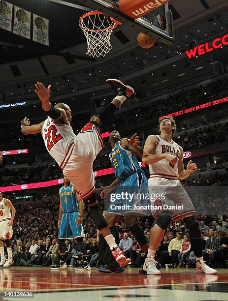 Taj Gibson of the Chicago Bulls falls to the floor after taking a shot against Solomon Jones of the New Orleans Hornets as Omer Asik gets into...