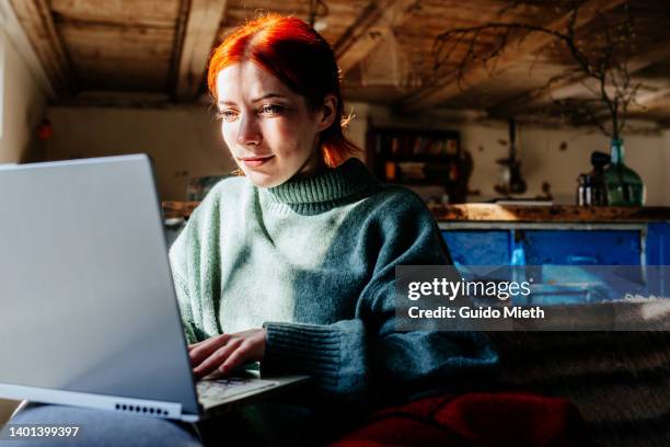 woman working with computer in rented appartment out of town. - log in stock-fotos und bilder