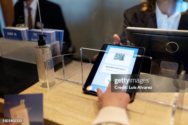hand of a guest doing online checking in at hotel reception using digital tablet - booking hotel foto e immagini stock