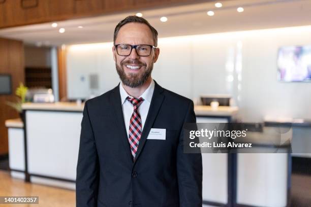 hotel manager in uniform at lobby - hotel manager stock-fotos und bilder