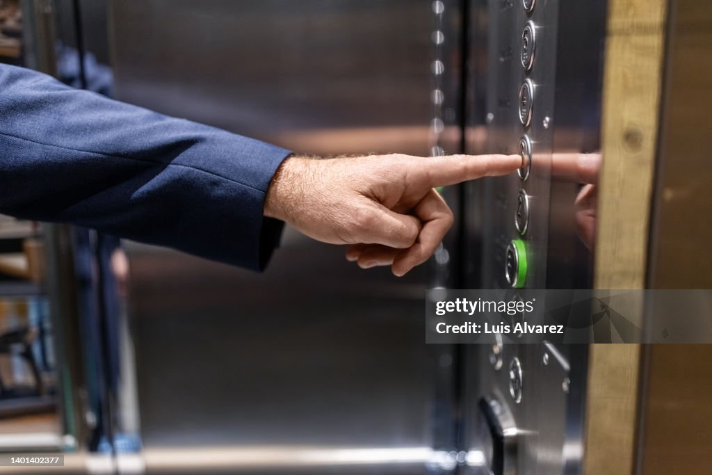 Close-up of a businessman using hotel elevator