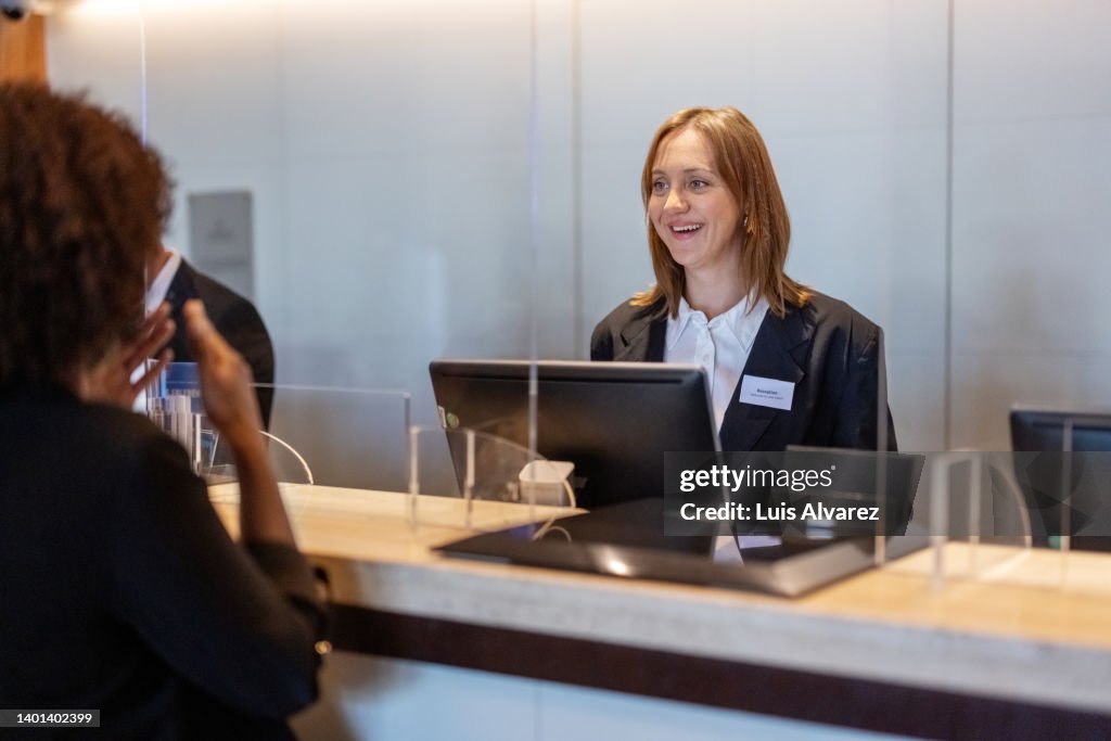 Receptionist assisting guest in hotel