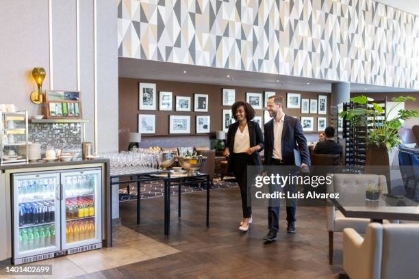 business partners walking towards the food counter in hotel lounge - floor walk business stock pictures, royalty-free photos & images