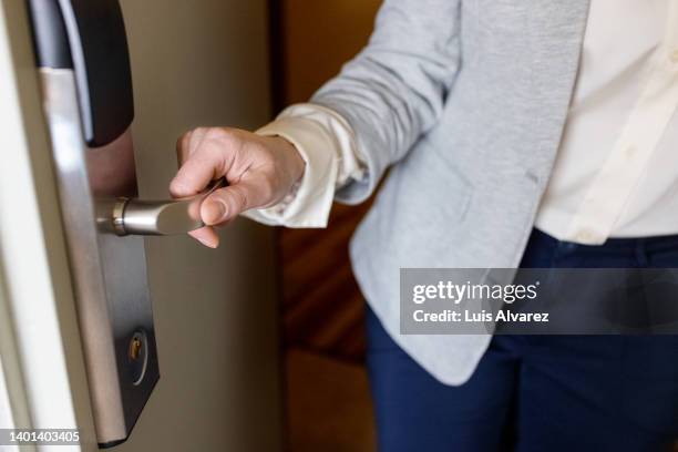 close-up of businesswoman hand opening hotel room door - self closing stockfoto's en -beelden